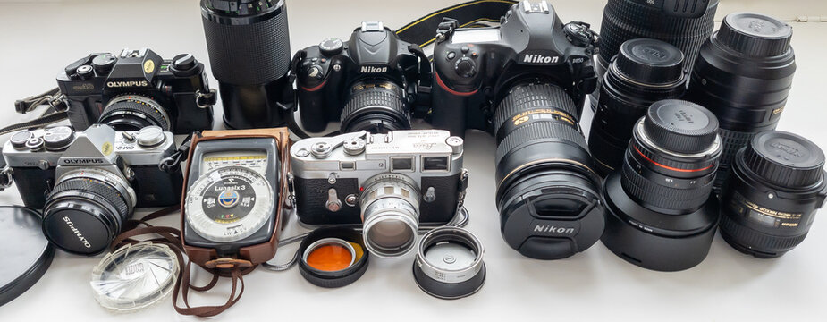 London. UK- 09.03.2024. A collection of vintage and modern day digital SLRs, lenses and other equipment isolated in white