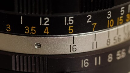 Vintage manual photographic lens with lenses and aperture and focal length marks, close-up