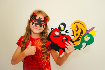 Unique child. Halloween. Child in Halloween carnival mask. The child made handmade felt masks for Halloween. Girl prepared for Halloween celebration. Bat, pumpkin, witch, skull and devil masks