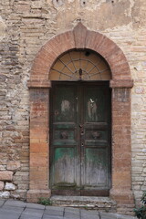 Aged Wooden Door with Brick Frame in Assisi, Umbria, Italy