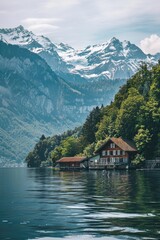 Fototapeta premium A peaceful lakeside residence with mountains in the background, suitable for use in travel or real estate marketing