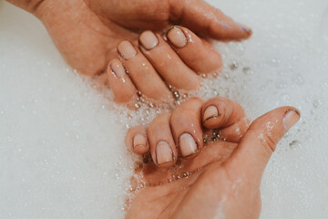 Hands of a girl after gardening with dirt under her nails who washes her hands with soap