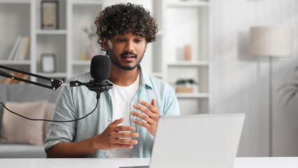 Microphone, podcast and Indian man speaker in his living room. Creative streamer, internet influencer or online content creator live streaming for audience.