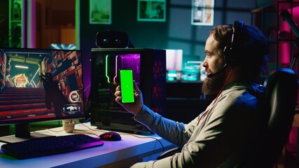 Man watching favorite content creator on isolated screen cellphone showing tips for game he is currently playing. Player stuck on difficult mission, looking online for inspiration on mockup phone