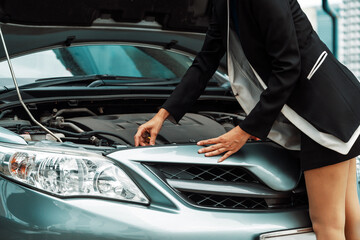 A business woman whose car breakdown try to fix the car by herself without help. uds