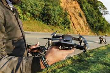 Traveling man flying a drone in a rural scene, nature and vegetation. Travel and road.