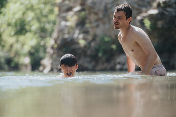 Two young men swimming in a serene natural water setting, enjoying a fun and refreshing outdoor experience on a sunny day.