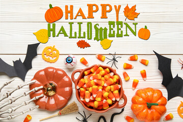 Halloween card with decorations and sweets on white wooden background
