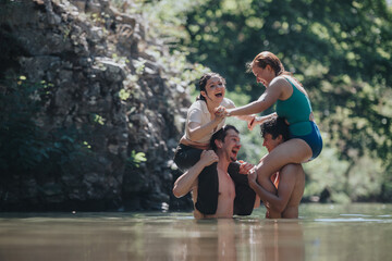 Group of cheerful friends playing in the water, enjoying a sunny day outdoors, and having fun together in nature.