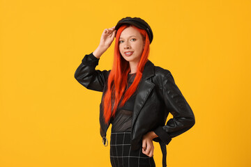 Beautiful young happy woman in autumn outfit on yellow background