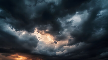 dark dramatic sky with black stormy clouds before rain or snow as abstract background, extreme weather, the sun shines through the clouds, high contrast photo