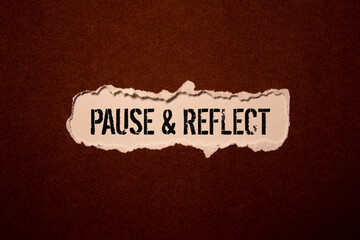 Pause and reflect word on a business card on a red notebook