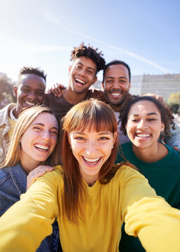 Group of happy friends posing for a selfie on a spring day as they party together outdoors. Group of multicultural friends having a good time together on the weekend.