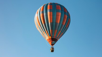 Naklejka premium A vibrant hot air balloon soaring against a clear blue sky, symbolizing adventure and leisure.