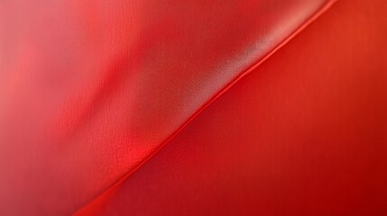 A close-up of a red fabric with a subtle texture, creating a diagonal line.