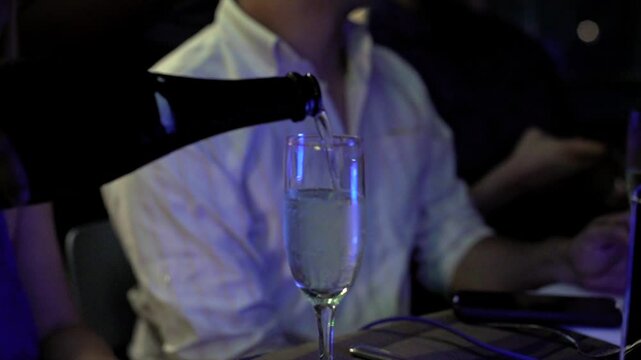 innkeeper serves a glass of champagne at a party