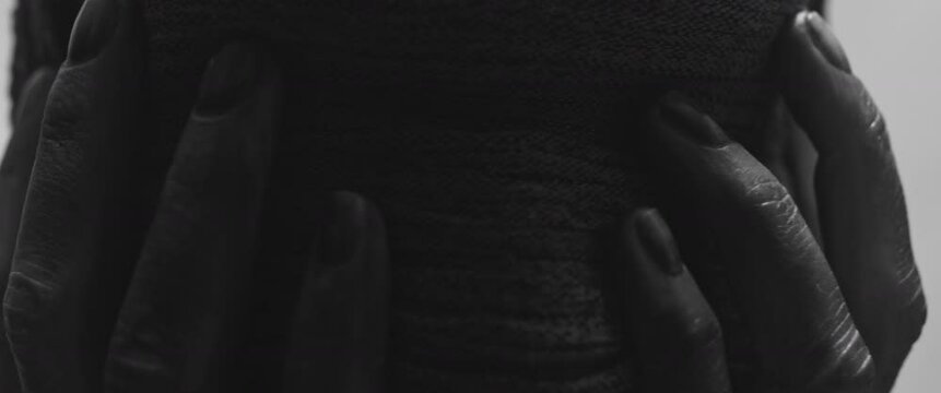 A mummy of a woman against the bright background in keeps her hands on her face the powerful pose full of despair