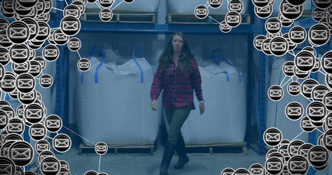 Image of envelope icons over caucasian female worker in warehouse - Powered by Adobe