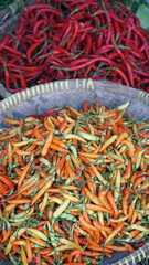 Red chili and cayenne pepper in a bamboo basket. Focus selected