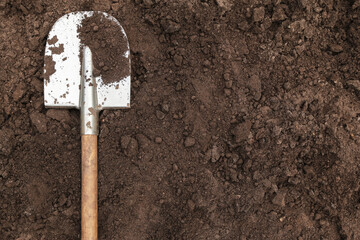 Brown dark soil ground texture background with copyspace and shovel top view. Organic farming, gardening, growing, agriculture concept © Viktor Iden