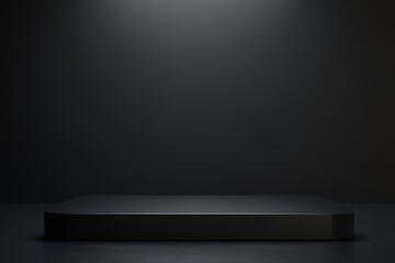Obraz premium A single, black, rectangular podium sits in the center of a dark room, illuminated by a spotlight above.
