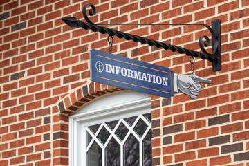 The exterior of a red and brown brick building with a white overhang. There's a black metal sign...