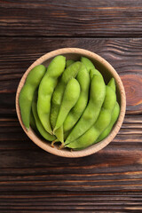 Raw green edamame pods on wooden table, top view