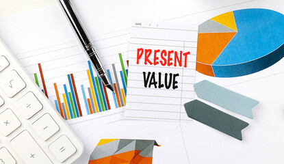 Present value concept with charts, calculator, and office supplies on a desk