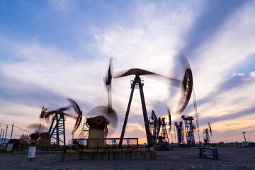 in the evening, oil pumps are running, The oil pump and the beautiful sunset reflected in the...