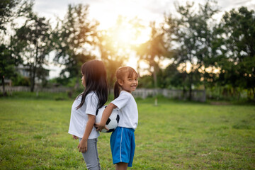 Fototapeta premium Two young girls are standing in a grassy field