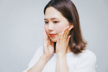 お肌に悩む女性　スキンケア
A woman worried about her skin