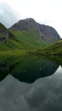 A majestic mountain reflects in a serene lake, highlighting Norway Urke region natural beauty. Its a perfect destination for nature lovers and adventurers seeking unique landscapes