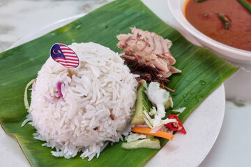 Authentic simple Nasi Dagang, popular delicacy in Terengganu served with mackerel fish fillet, and...