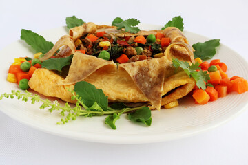 Omelet, stuffed with stir-fried pork and basil, carrots, corn, green peas, decorated with basil leaves and flowers.

