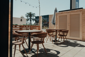 Dubai, UAE - February 14 2020: Outdoor seating area at a cozy cafe on Jumeirah Road