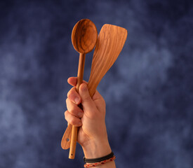 Hand mit Holzkochlöffel