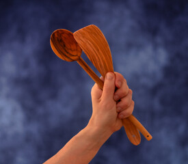 Hand mit Holzkochlöffel