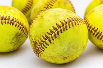 Yellow softballs with visible stitching on a white background