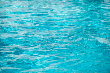 Ripple Water in swimming pool with sun reflection. Wavy water background.