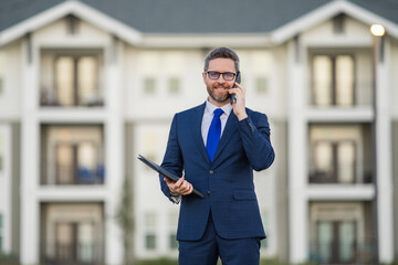 Real estate agent business man in suit hold holder clipboards and talking on phone. Businessman....