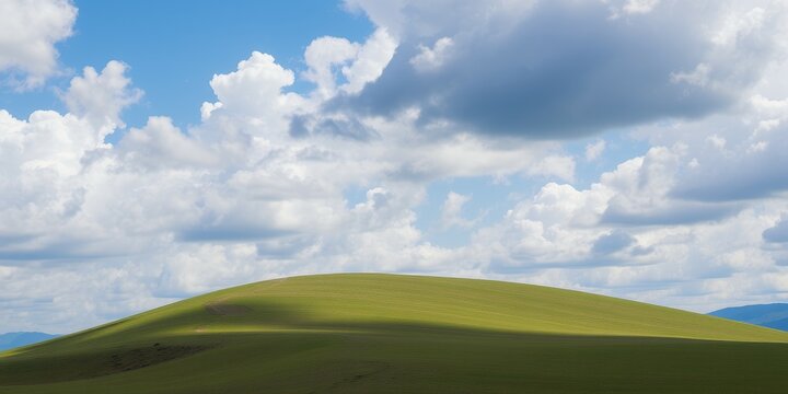 A rolling green hill under a bright blue sky with fluffy clouds.