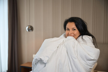 45 plus lady is wrapped in a fluffy blanket