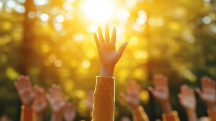 student raises their hand in a classroom, the focus on the hand while the background remains blurred. The image symbolizes curiosity, engagement, participation, and the pursuit of knowledge