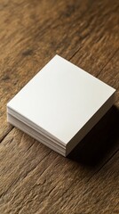 Fototapeta premium Stack of blank white cards on a wood table.