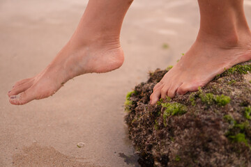 Feet on a Rocky Beach with Moss