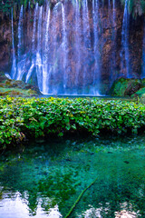 Plitvice Lakes National Park. Croatia. Big waterfalls. Nature travel background. Beautiful summer nature. Plitvice waterfalls in Croatia. Mountain streams flow into a lake with azure clear water.