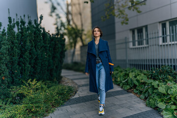 Fototapeta premium Confident young woman walking in urban surroundings