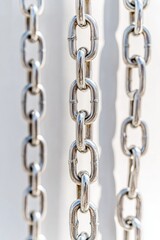 Fototapeta premium Silver Chains Pattern on Bright High-Contrast White Background with Crisp Daylight Shadows