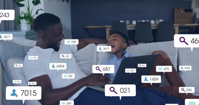 Social media analytics animation over father and son using laptop on couch