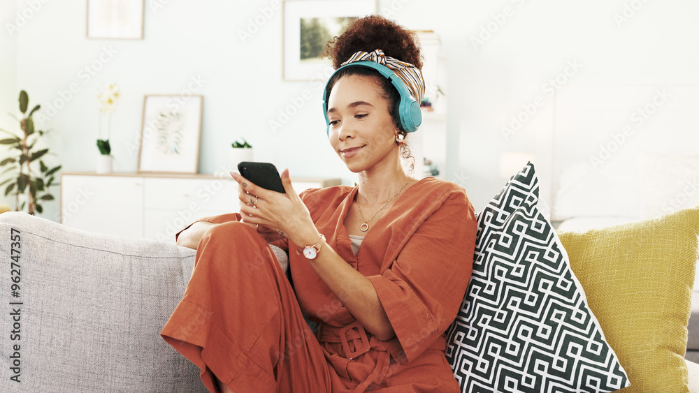 Poster Happy woman, relax and phone with headphones on sofa for music, listening or online streaming at home. Young, female person or user with mobile smartphone for podcast, sound or playlist at house